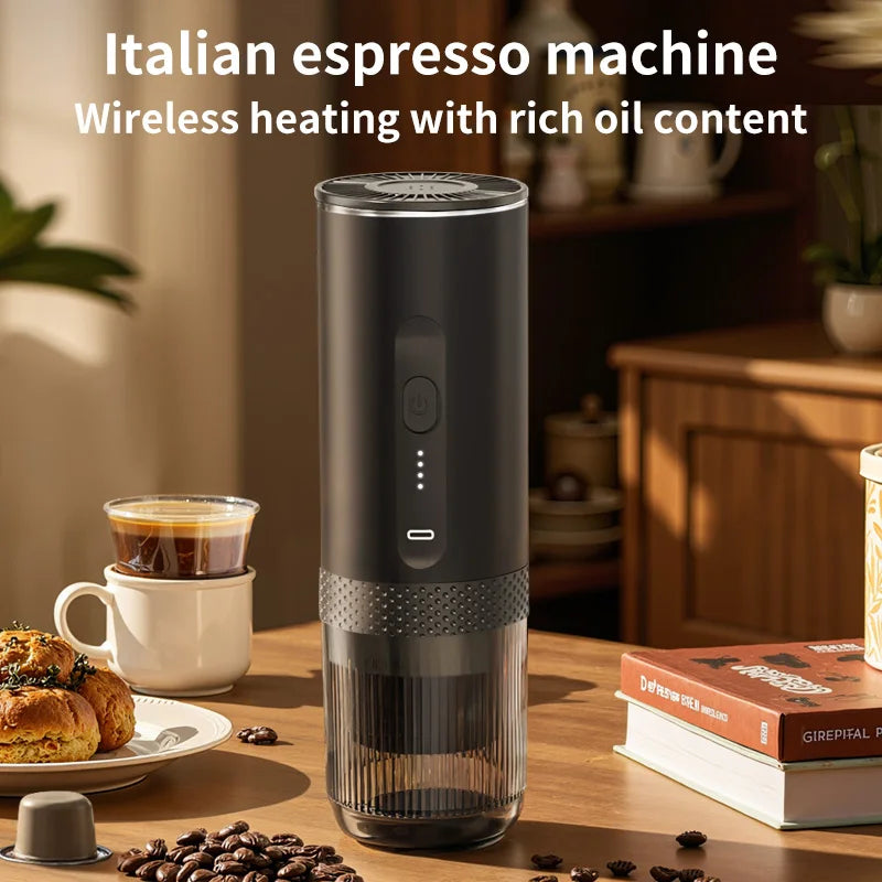 Portable black wireless Italian espresso maker with sleek cylindrical design and clear water chamber on wooden table.