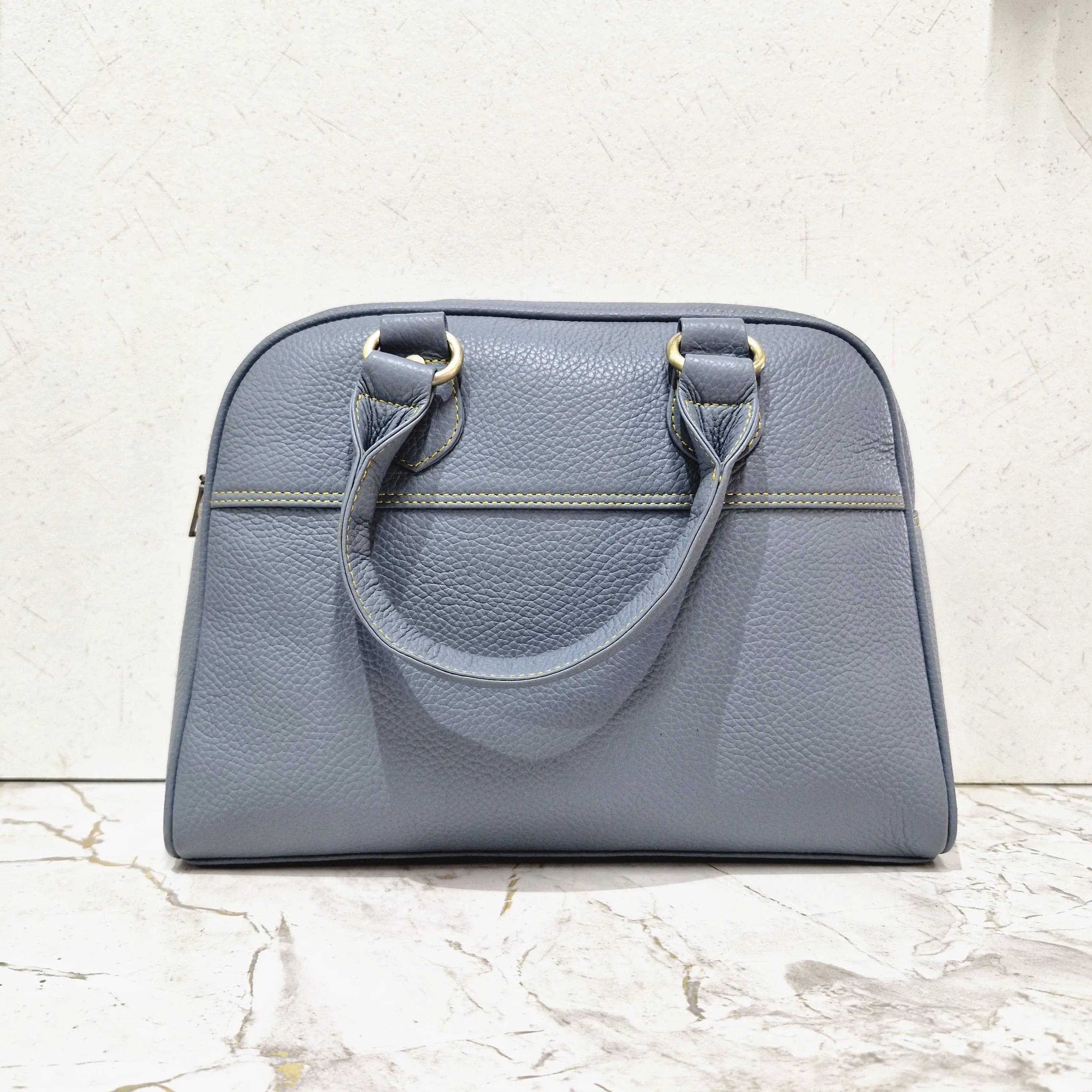 Blue genuine leather designer mini tote bag with dual handles, contrast yellow stitching, and gold-tone hardware.