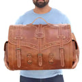 Large brown vintage leather trunk bag with buckle straps, brass stud detailing, and spacious design for travel.