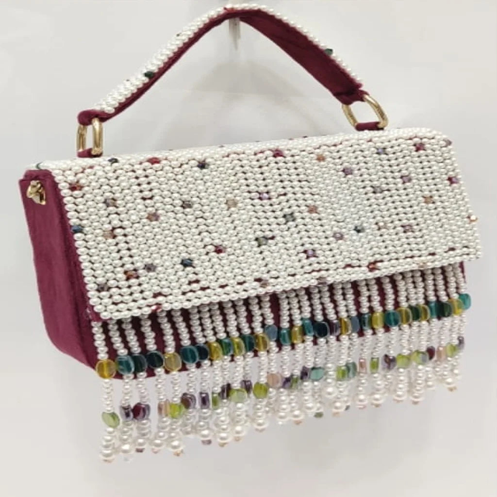 Maroon designer clutch with pearl embroidery, crystal tassel fringe, and beaded handle for weddings and parties.