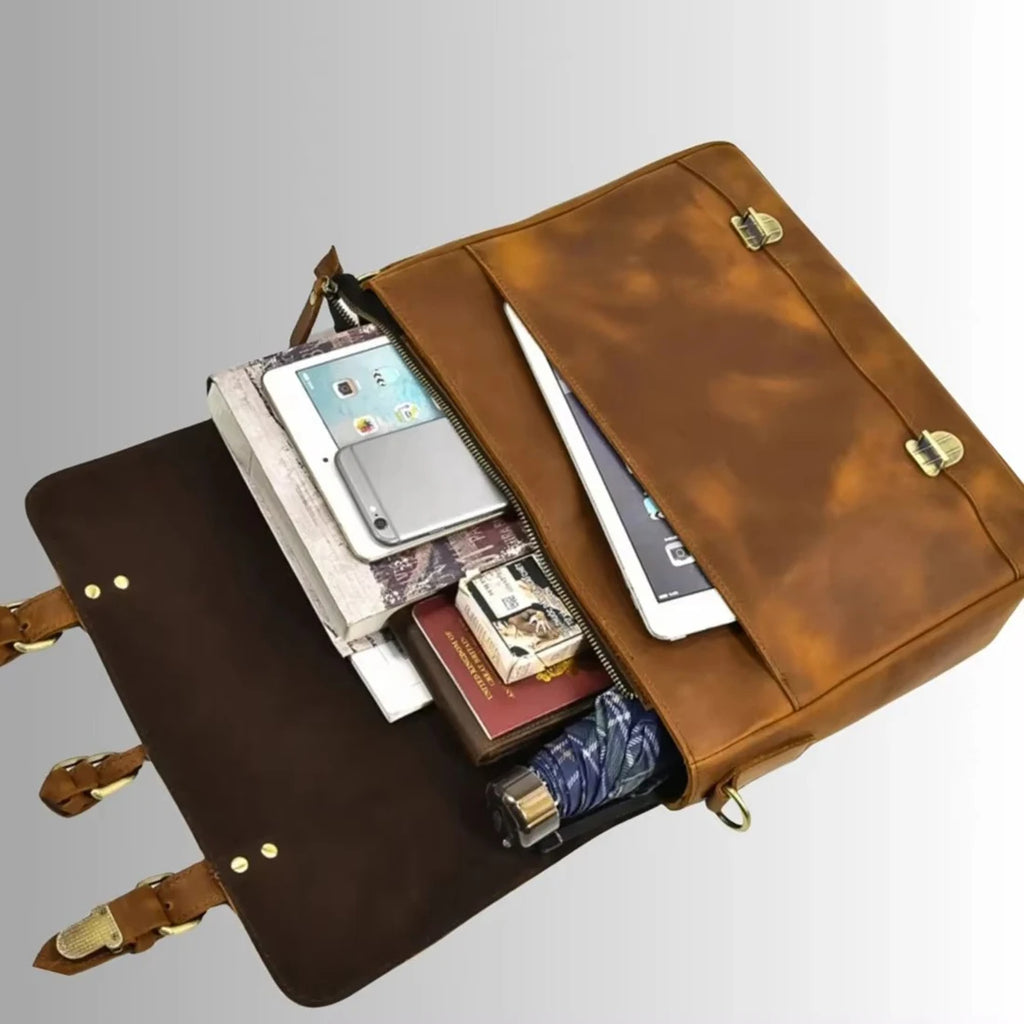 Brown leather business laptop briefcase, messenger style with brass buckles, organized interior, and organizer pockets.