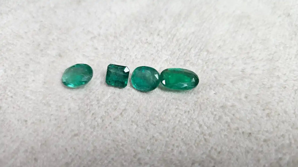 Loose green emerald-cut gemstone mix, five small stones in mixed shapes on felt