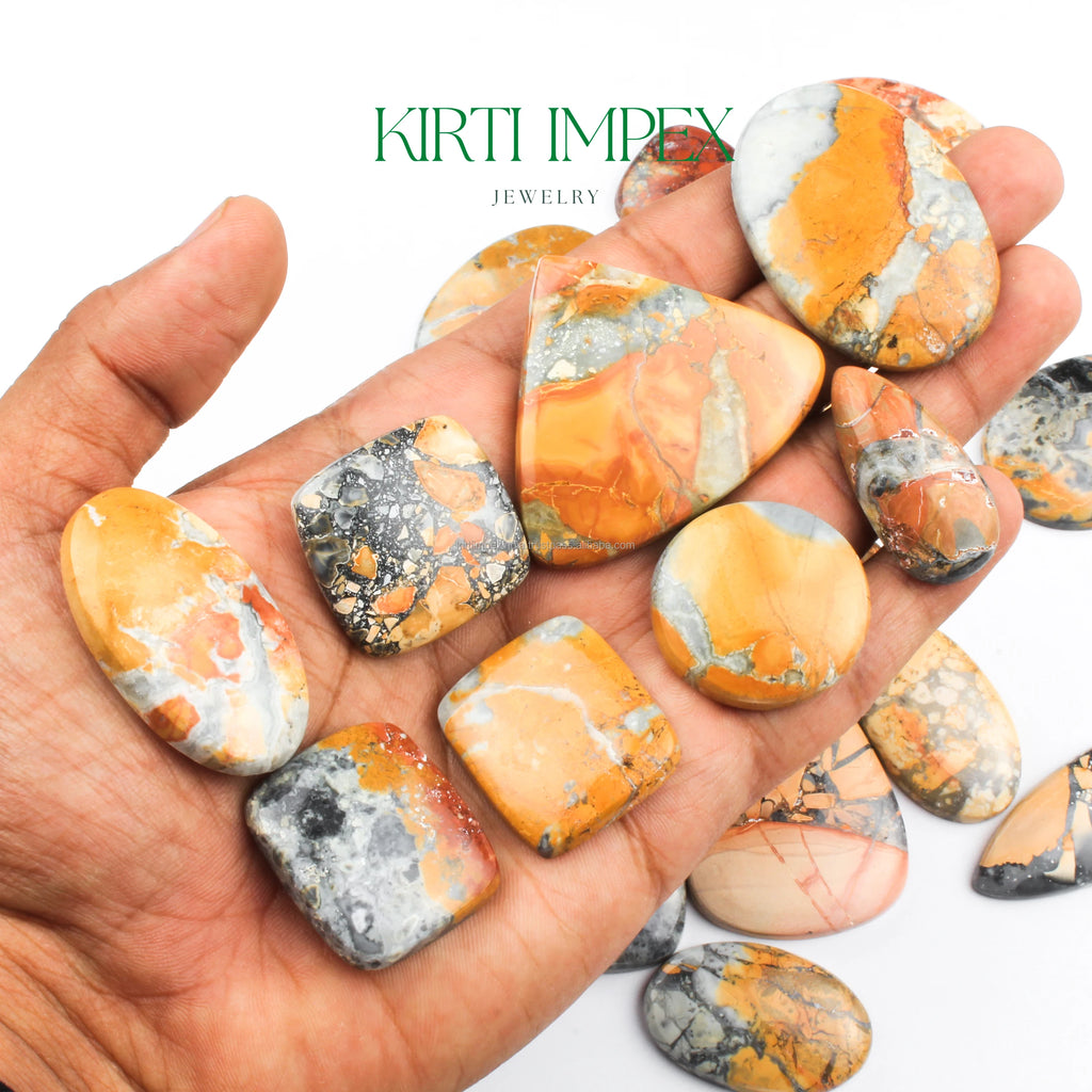 Yellow-orange jasper cabochons shown in open palm, flat-back loose stones