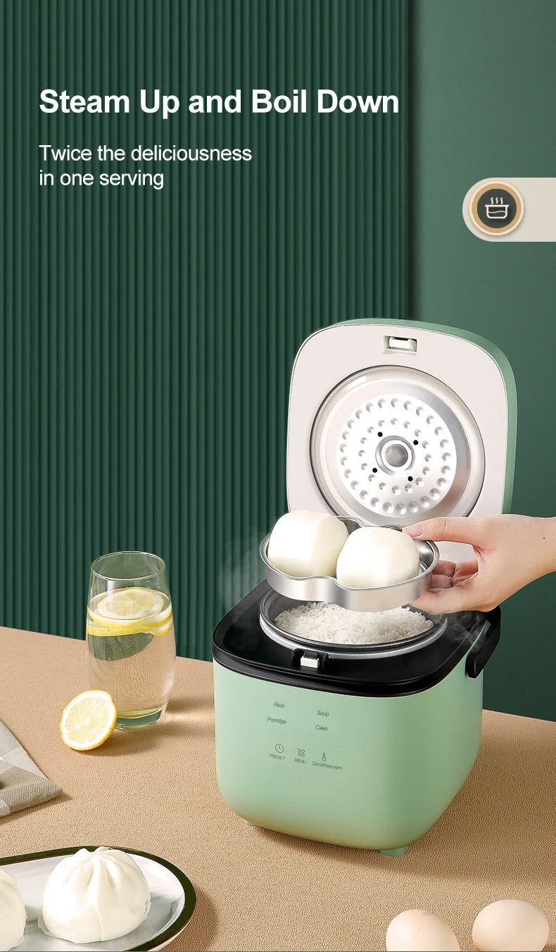 Mini electric rice cooker steaming with lid open, mint green body and inner steaming plate