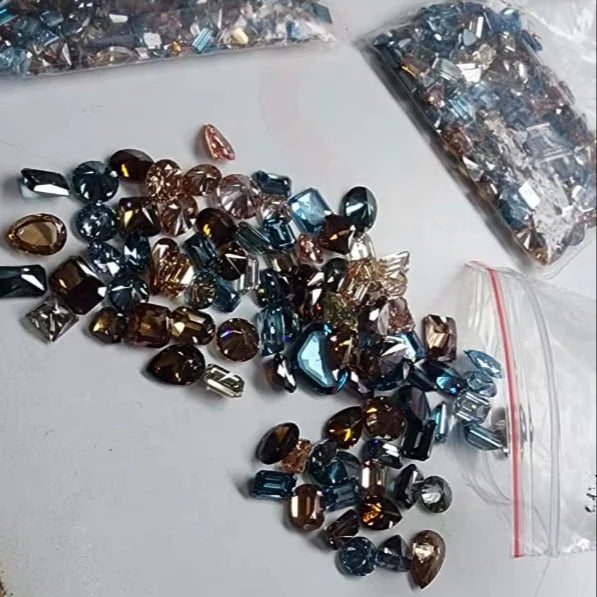 Loose faceted lab-grown diamond stones, blue and brown mix with dark sparkle