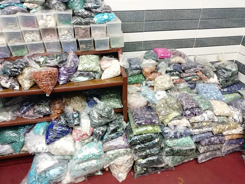 Mixed-shape cabochon gemstone lots stacked in sealed bags on shop shelves