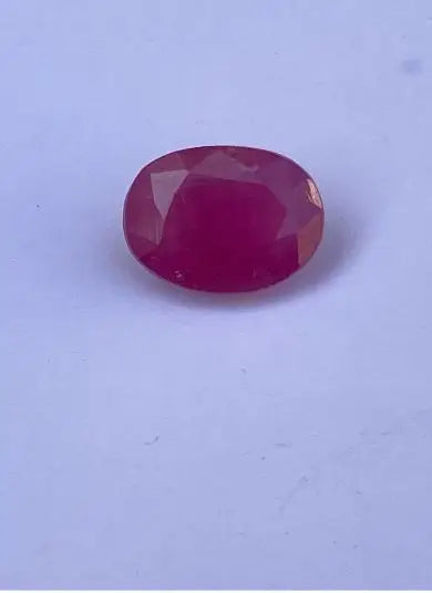 Oval faceted red gemstone, smooth polished surface
