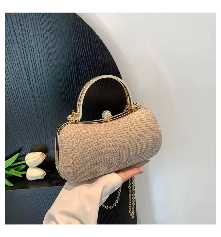 Champagne glitter evening clutch bag with crystal-embellished gold handle and clasp for weddings and parties.