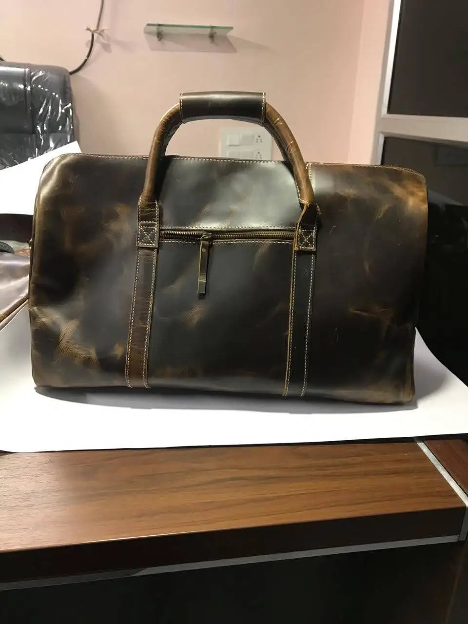 Large brown full-grain leather gym trunk, durable luxury travel duffel with sturdy handles and front zippered pocket.