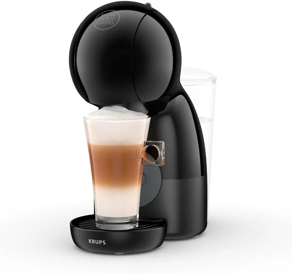 Black Krups Nescafé Dolce Gusto pod coffee machine brewing a layered latte in a glass cup on a white background.