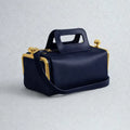 Navy blue retro PU leather pillow bag with gold clasp hardware, top handle, and detachable shoulder strap.