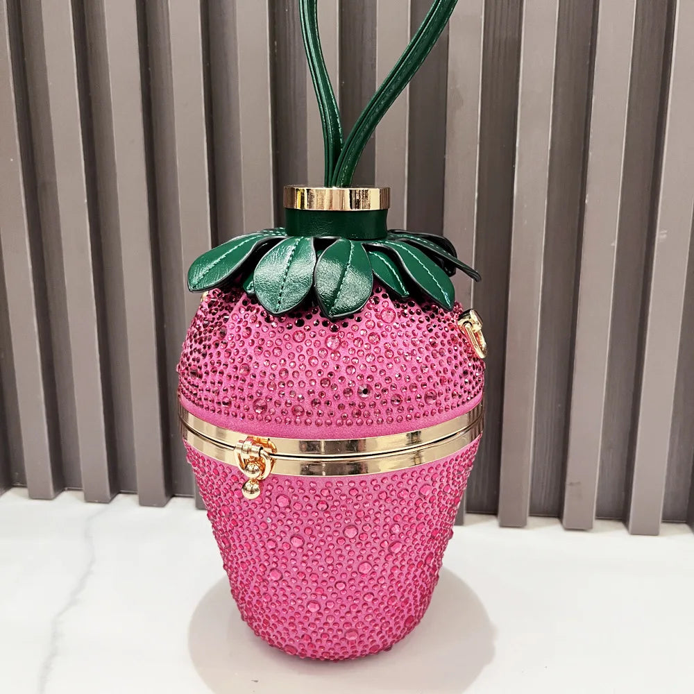 Pink rhinestone strawberry designer clutch with gold hardware, green leather leaves, and handle for evening banquets.