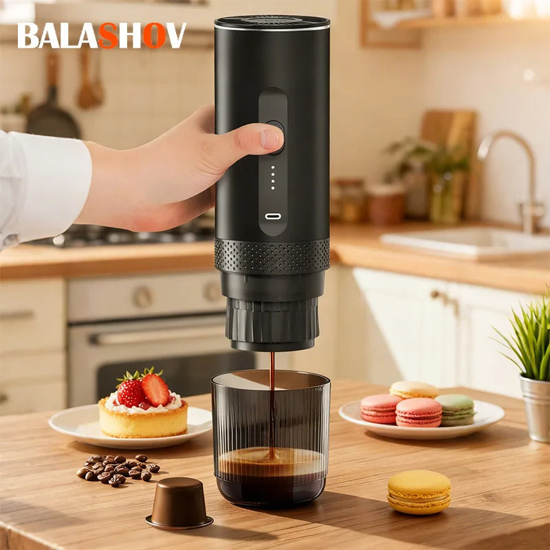 Balashov portable matte black espresso maker brewing coffee into a ribbed glass cup on a wooden kitchen table.
