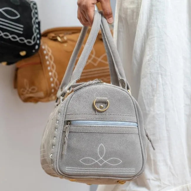 Grey handmade suede leather travel duffel bag with white boot stitch embroidery, side zipper, and durable trunk style.