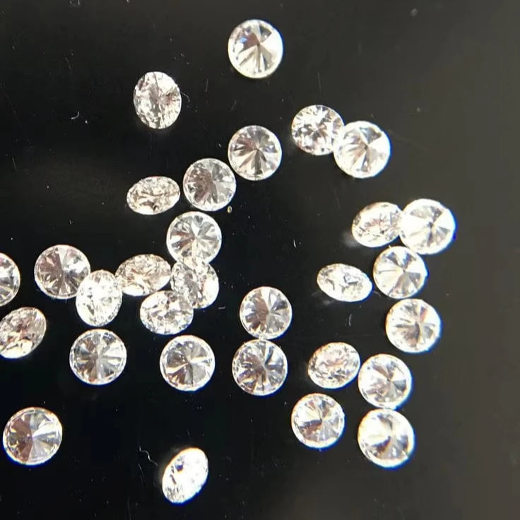 Loose round white diamonds, scattered assortment of small faceted stones