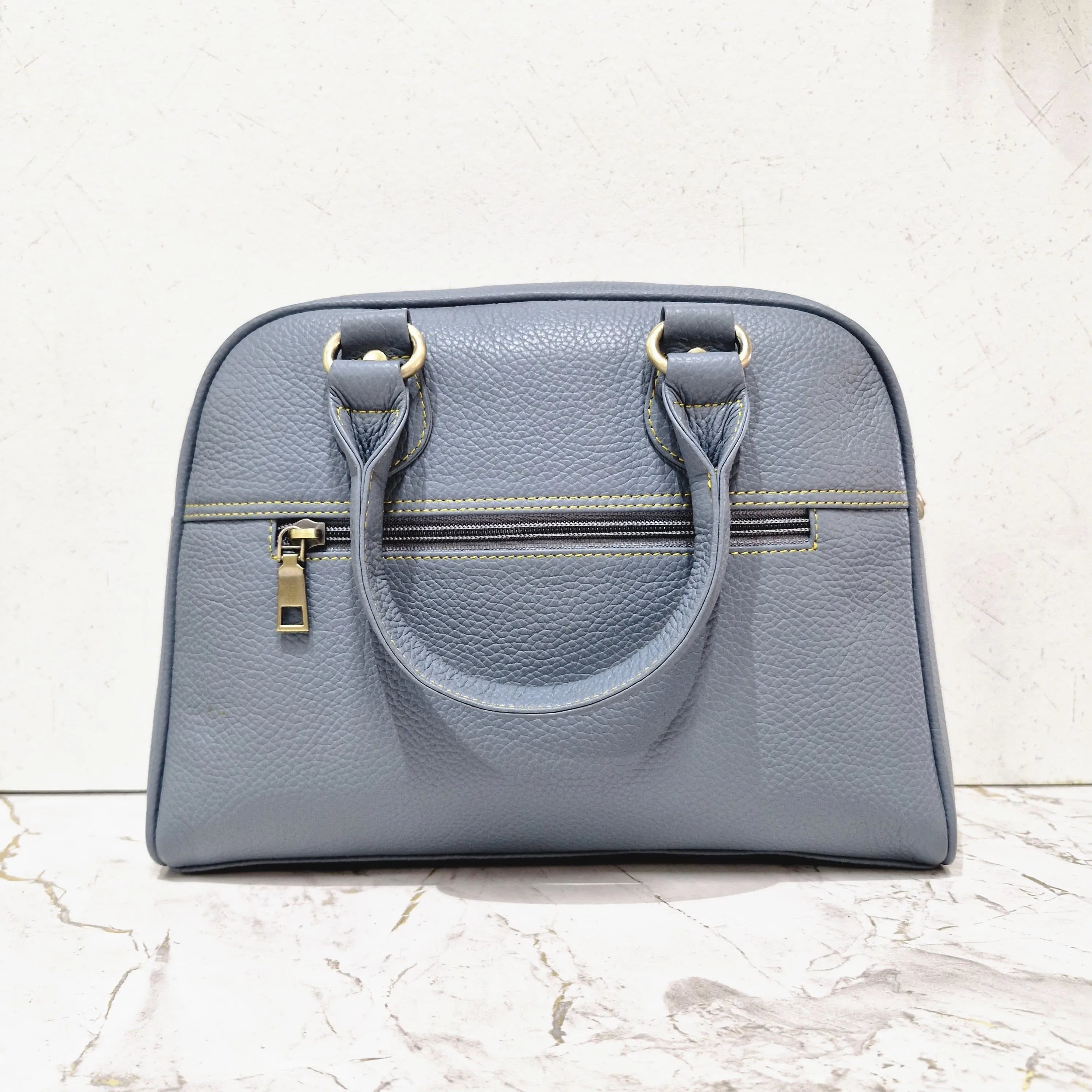 Grey genuine leather mini tote designer handbag with top handles, zipper pocket, and contrast stitching detail.