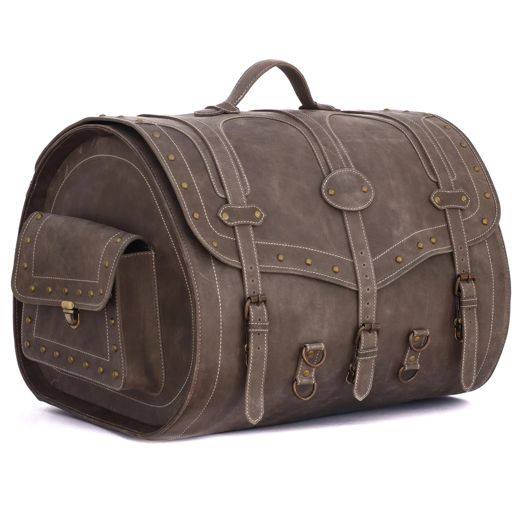 Vintage-style brown leather trunk bag with brass stud detailing, buckle straps, and large capacity for travel or fitness.
