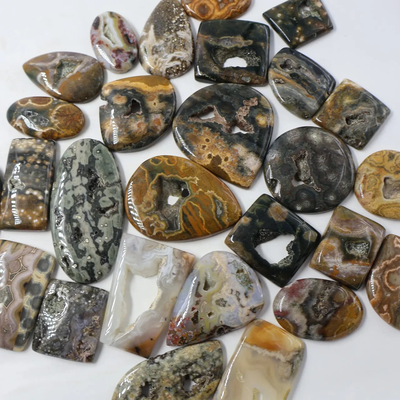 Mixed ocean jasper druzy cabochon gemstones, oval and teardrop shapes with dark and amber patterns