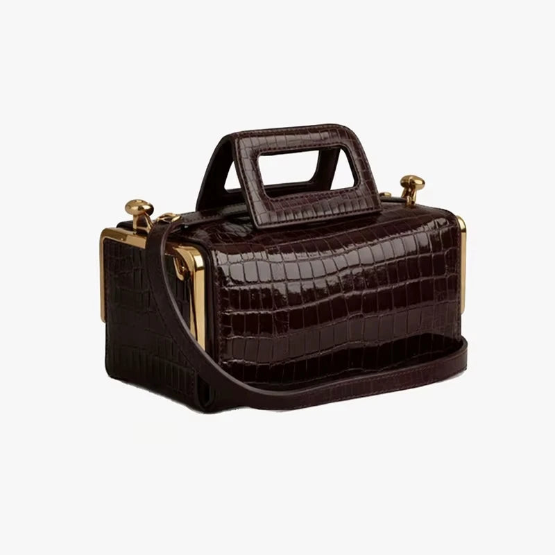 Dark brown crocodile-embossed PU leather designer handbag with gold clasp frame and rectangular top handle.