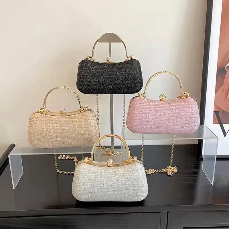 Set of four glitter designer handbags in black, gold, pink, and silver with gold handles and crystal clasp closures.
