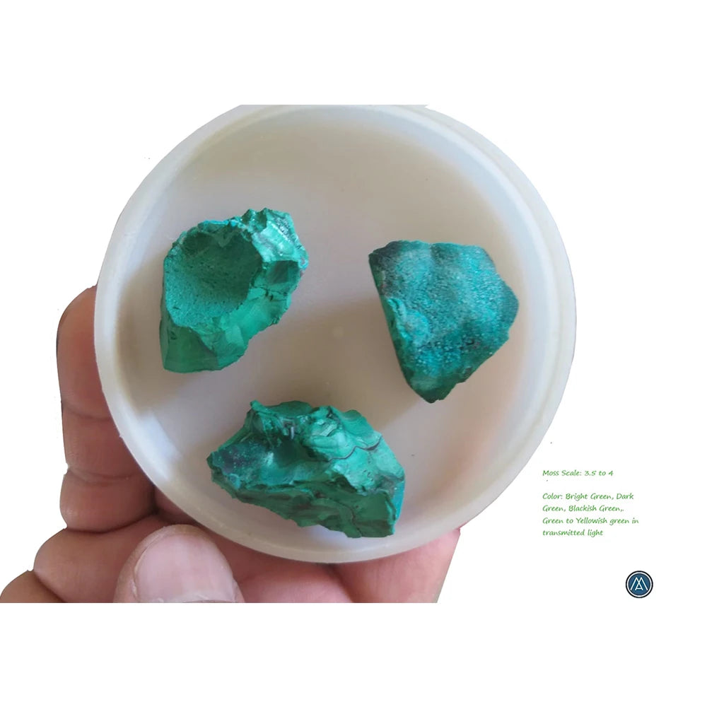 Three raw teal-green malachite crystal pieces in a white bowl