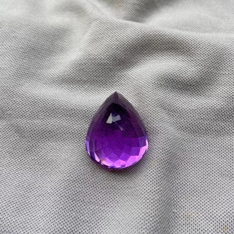 Amethyst teardrop (pear) cut gemstone in rich purple with clear facet pattern