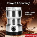 Compact stainless steel electric coffee bean grinder with a clear lid for fresh grinding, isolated on brown background.