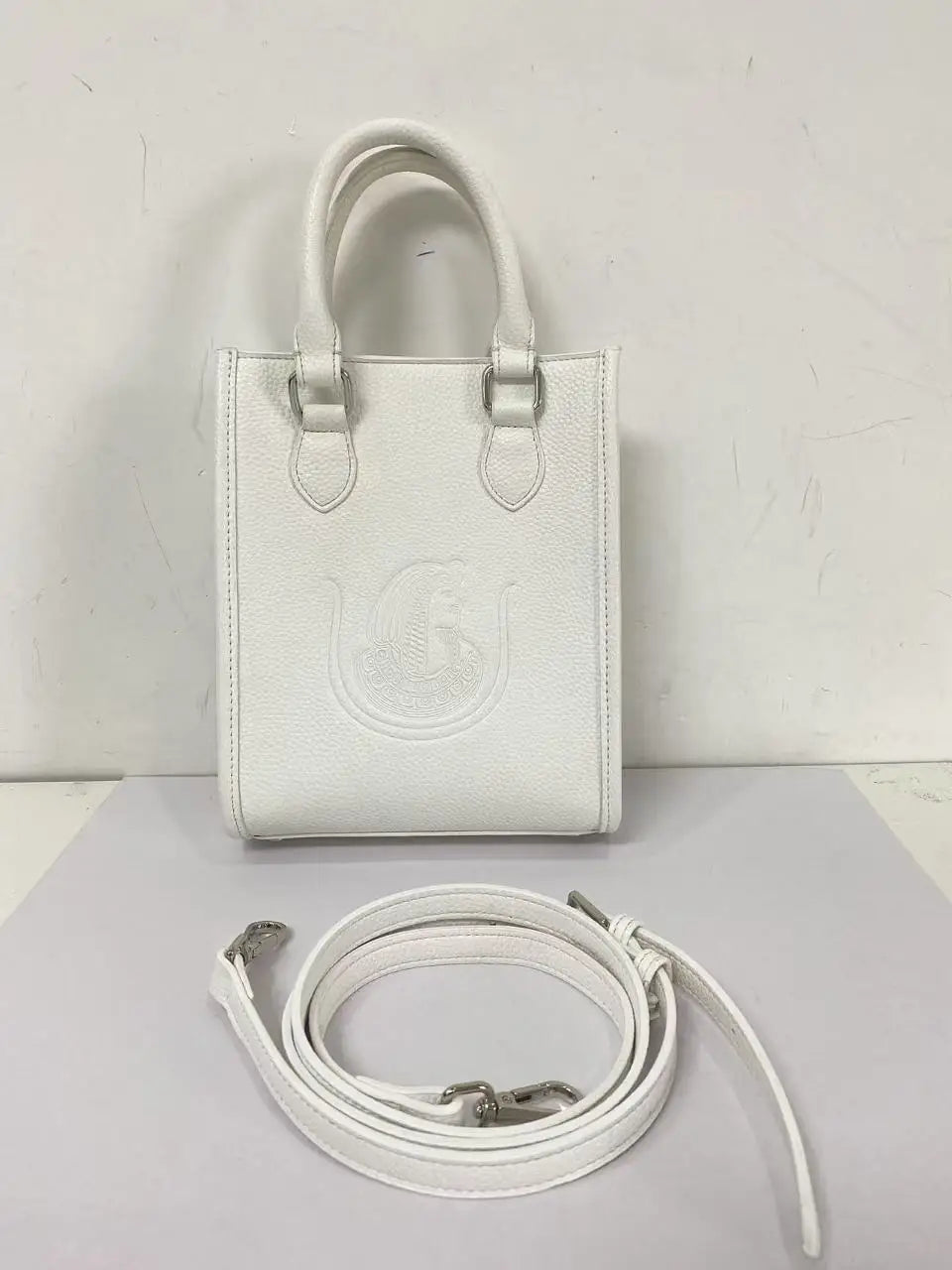 White genuine leather luxury crossbody bag with Eastern Star embossed design, top handles, and detachable strap.