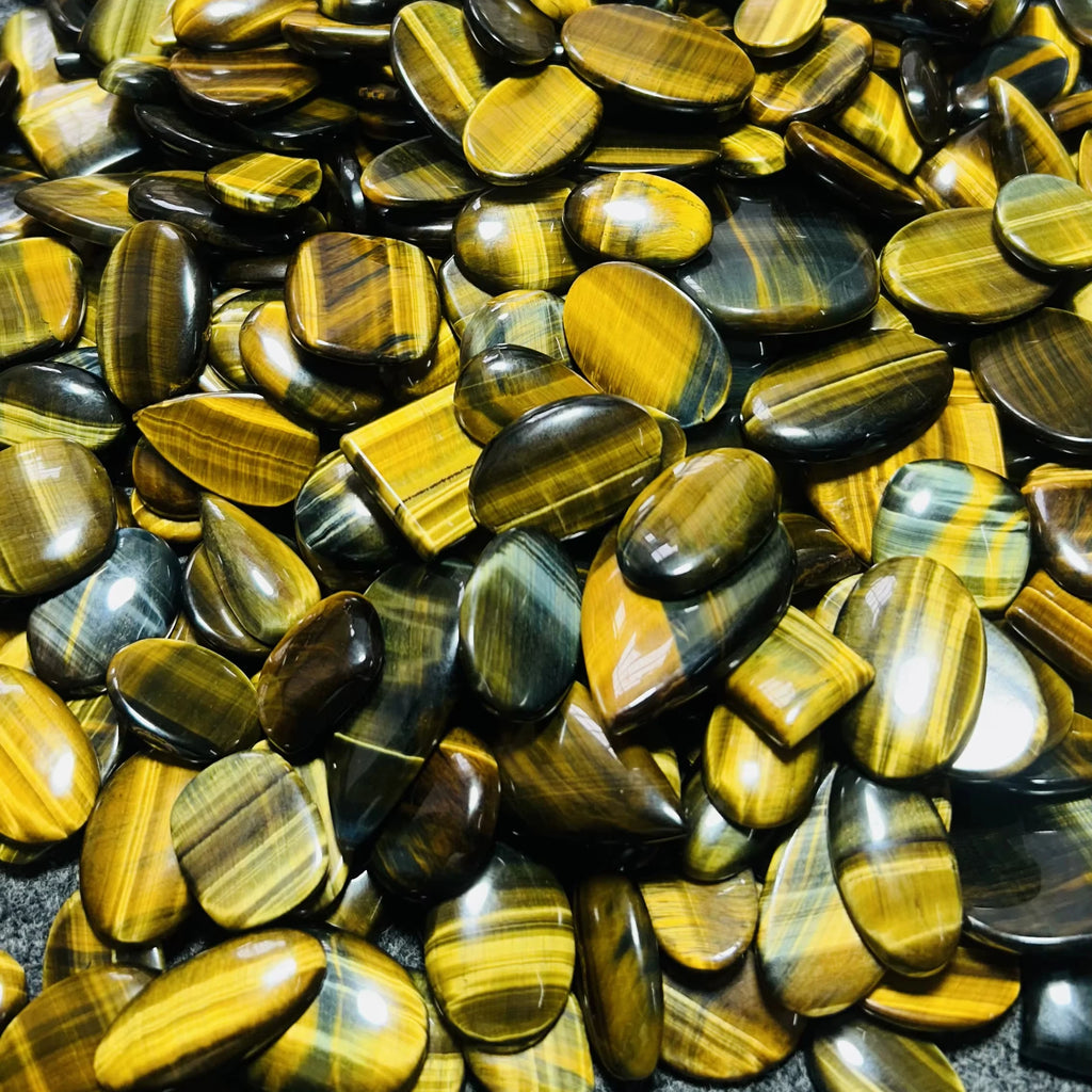 Yellow and gold striped cabochon gemstones, glossy smooth oval shapes
