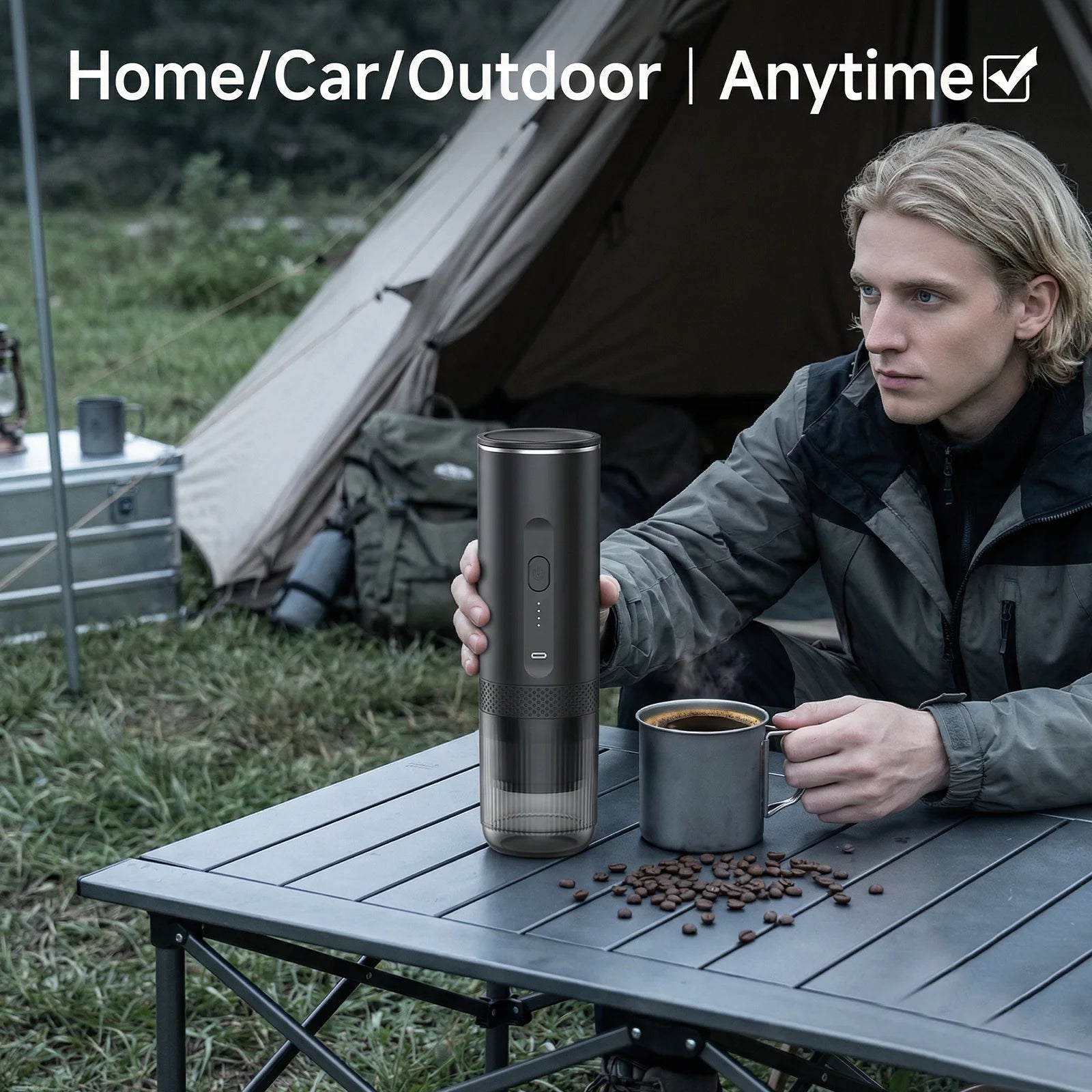 Portable matte black electric coffee maker for camping and travel on a foldable table outdoors.