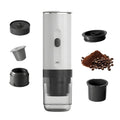 White portable electric coffee maker for ground coffee and capsules with accessories and charging port on white background.
