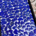 Lapis lazuli gemstone cabochons, smooth blue oval and round stones in close-up