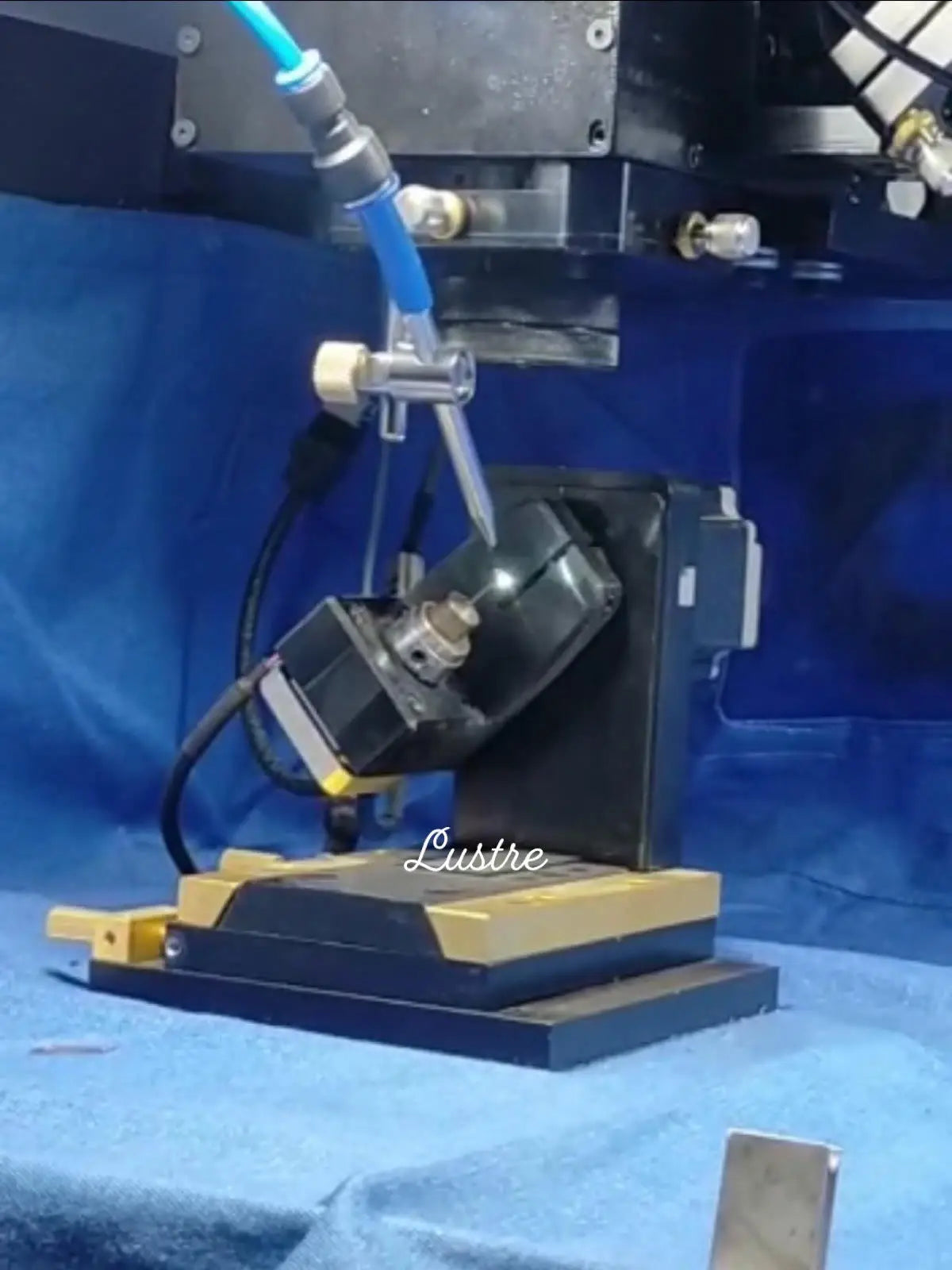 Jewelry polishing or cutting machine on a workbench with blue protective covering