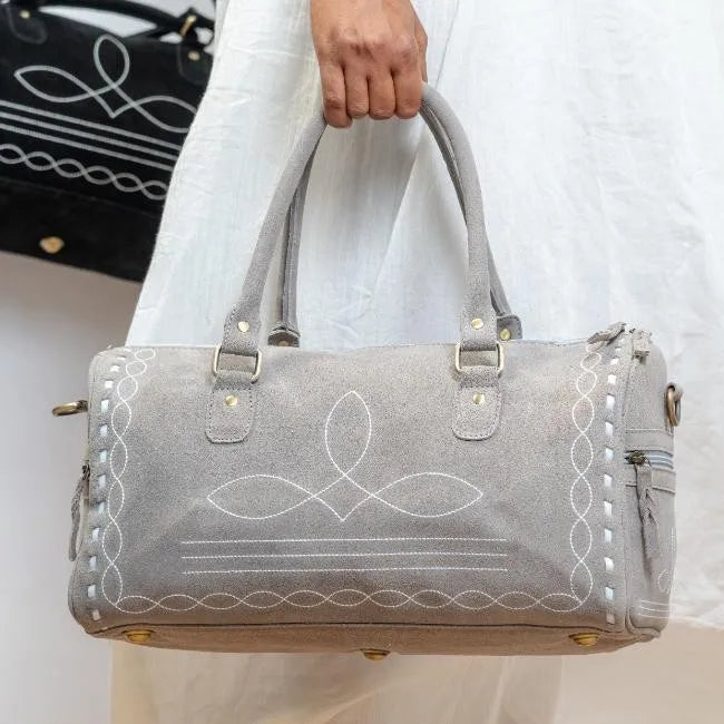 Grey handmade genuine leather duffel trunk with elegant white boot-stitch embroidery for stylish weekend travel.