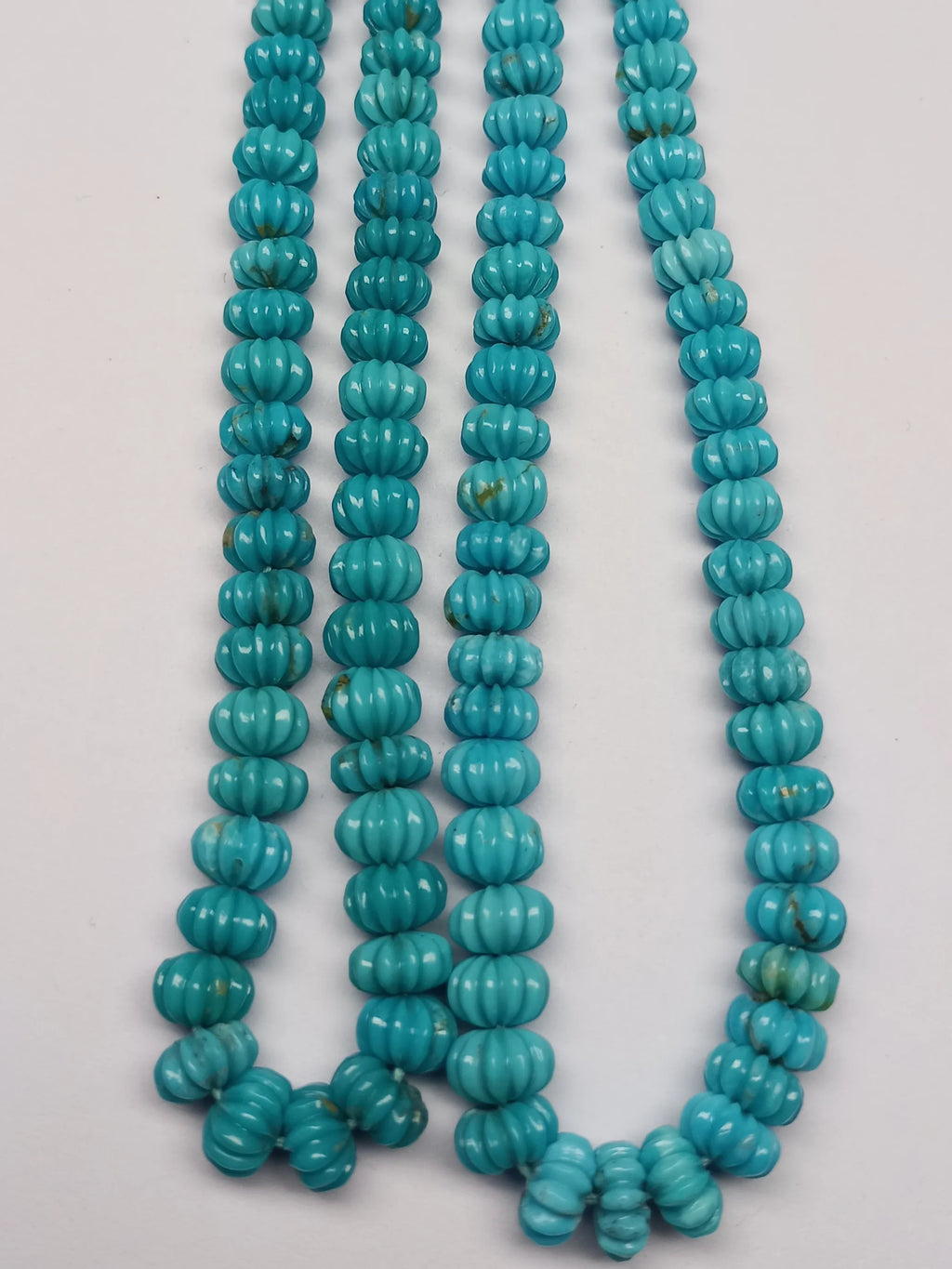 Multiple blue turquoise carved pumpkin-shaped bead strands, small ribbed pumpkin-carved beads