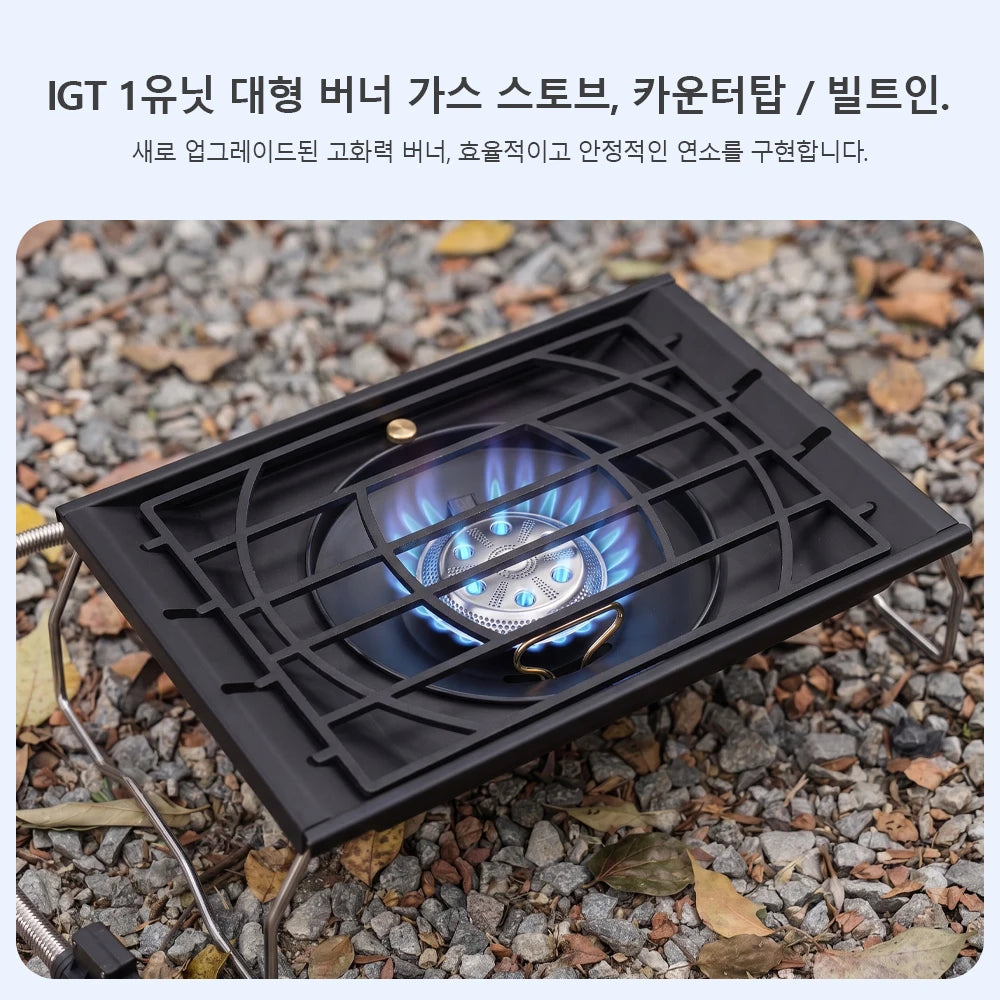 Camping stove showing blue flame burner through black geometric grate on rocky ground
