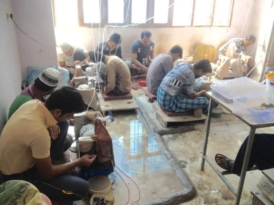 Gemstone cutting workshop with workers using tools at workbenches