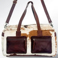 Handmade vintage Western duffel bag in white and brown cowhide leather with two dark brown front zip pockets. Trunk.