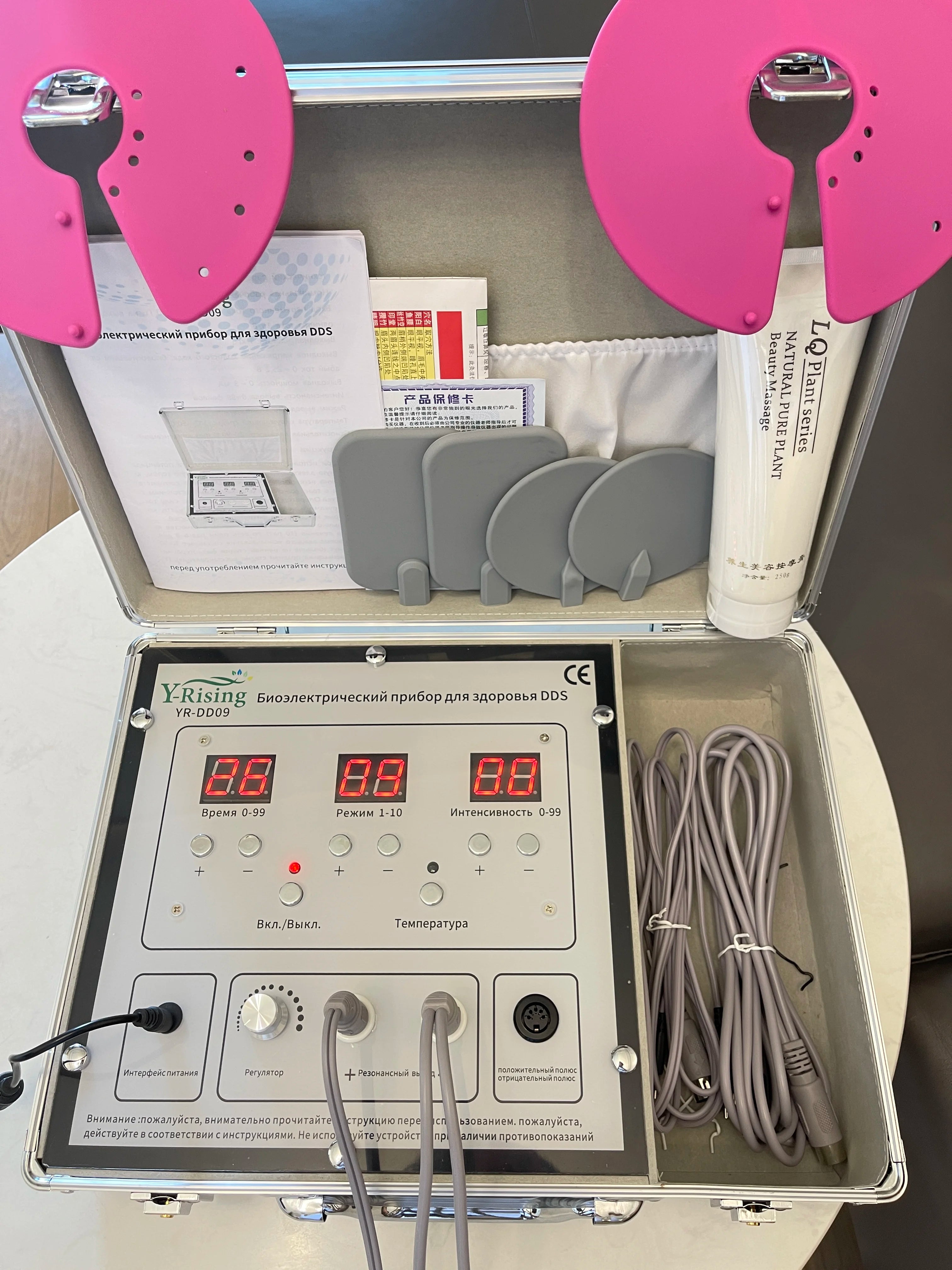 DDS bioelectrical body therapy massager kit with digital control panel, pink massage pads, and conducting gel in case.