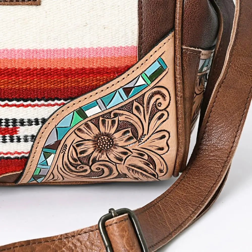 Handwoven western trunk with tooled floral leather, turquoise accents, and striped fabric overnight travel bag.