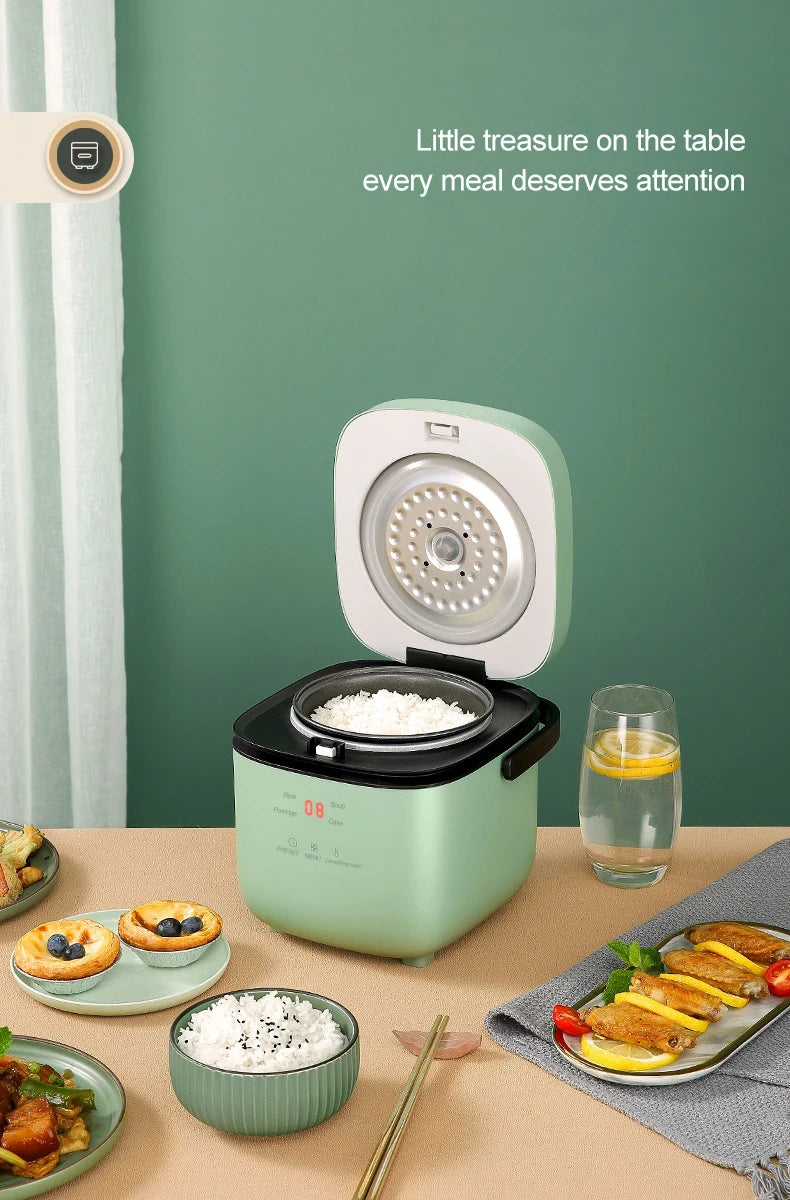 Mini electric rice cooker on table, teal body with open lid and steaming rice