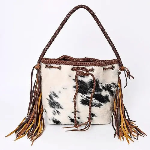 Vintage cowhide bucket handbag with fringe, braided handle, and drawstring closure. Trendy western-style trunk purse.