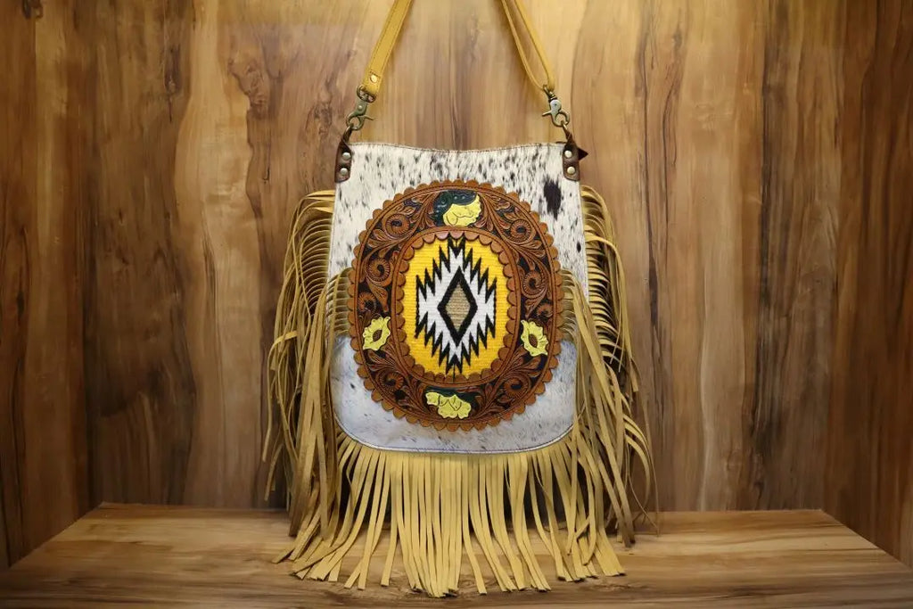 Handmade cowhide leather crossbody trunk bag with western tooling, yellow fringe, and geometric center design.