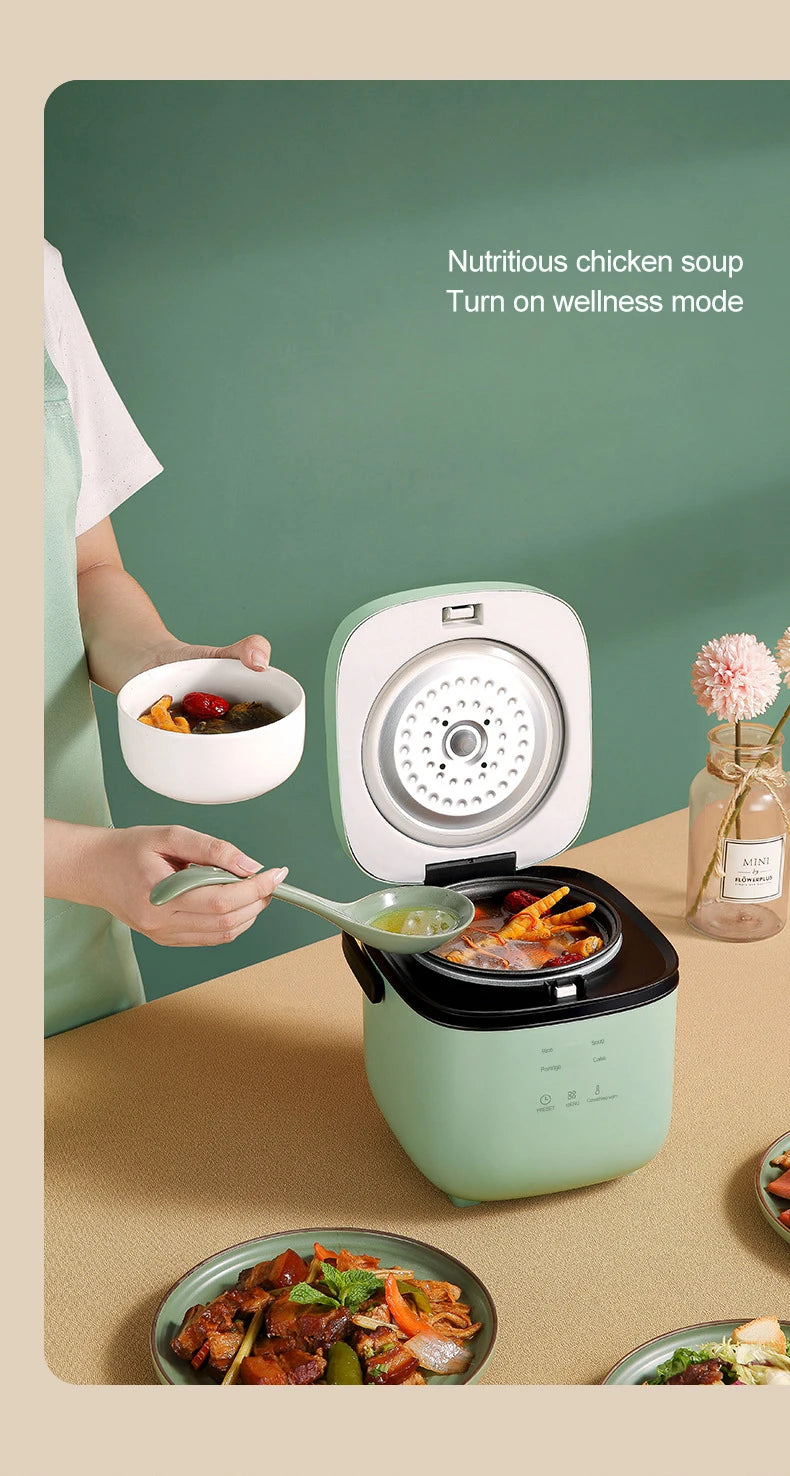 Mini rice cooker with lid open showing steaming inner pot, mint-green body