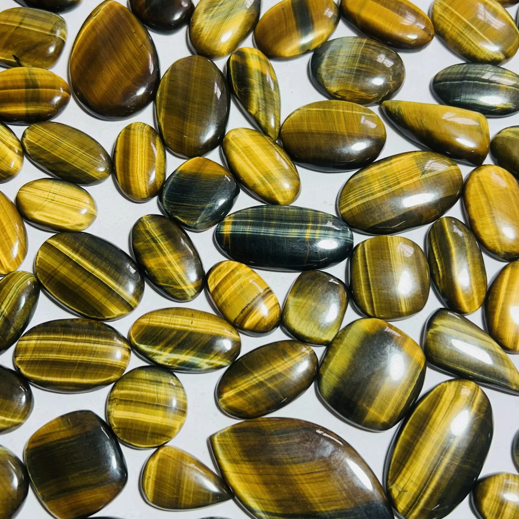 Glossy striped cabochon gemstones, smooth polished yellow-gold ovals
