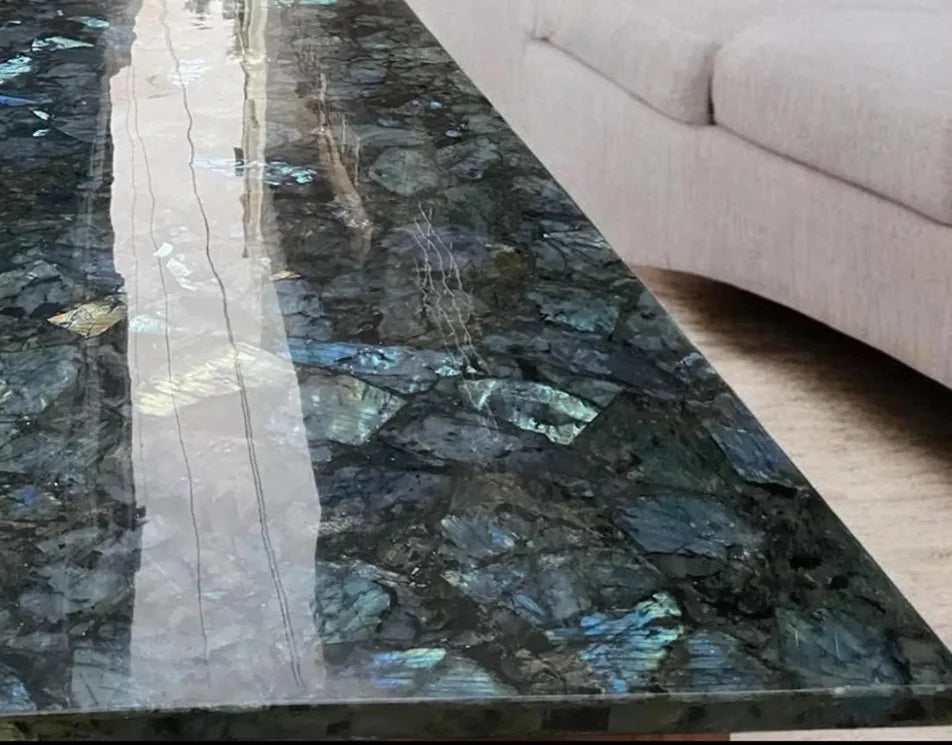 Labradorite gemstone tabletop close-up with blue flashes in a dark gray mosaic