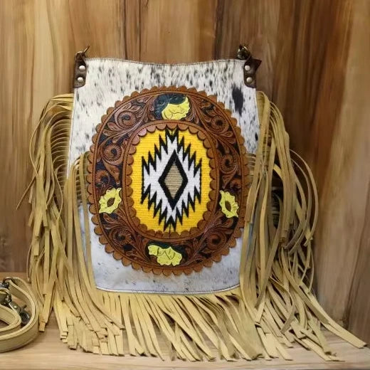 Genuine leather trunk crossbody bag with tooled western pattern, fringe, and yellow geometric inlay on hair-on hide.