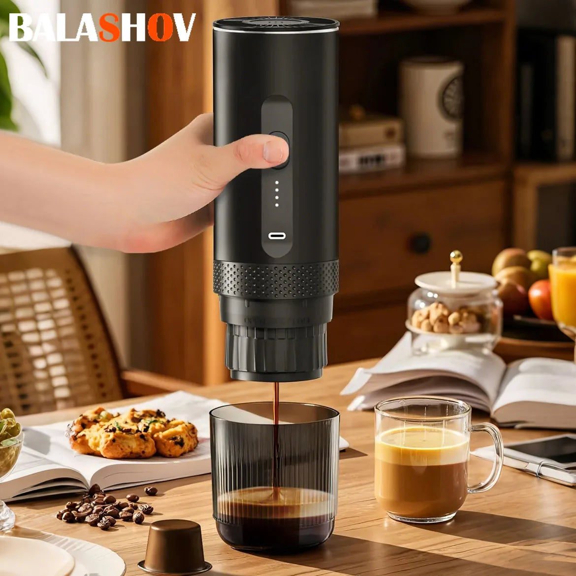 Balashov portable black electric coffee maker brewing into a glass cup on a wooden table.