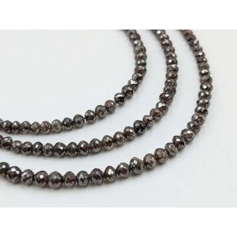 Faceted rondelle diamond beads on strand, reflective dark gray tones
