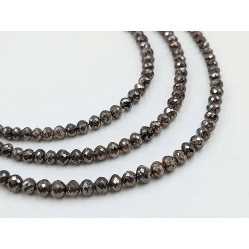 Faceted rondelle diamond beads on strand, reflective dark gray tones